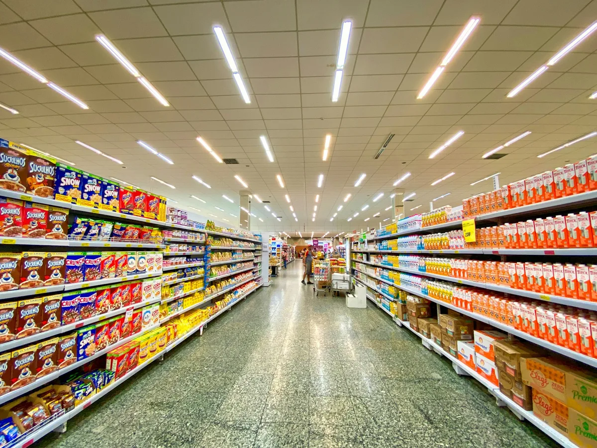 Modern supermarket interior with organized grocery aisles and soft architectural lighting